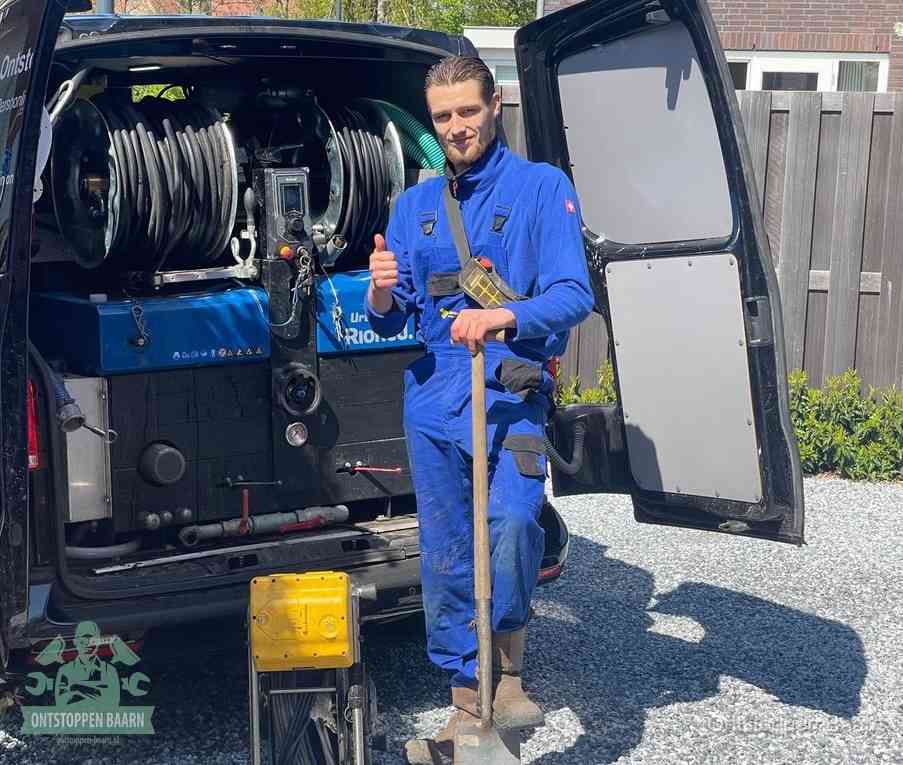 Een tevreden monteur met opgestoken duim naast de bestelbus, slim en snel ingrijpen bespaart geld bij een verstopping in Baarn
