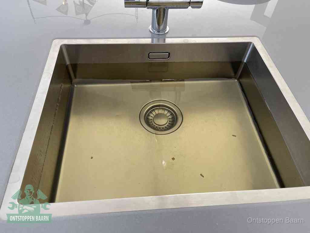 Een RVS spoelbak met stilstaand water dat niet wegloopt, een van de eerste signalen van een beginnende verstopping in Baarn