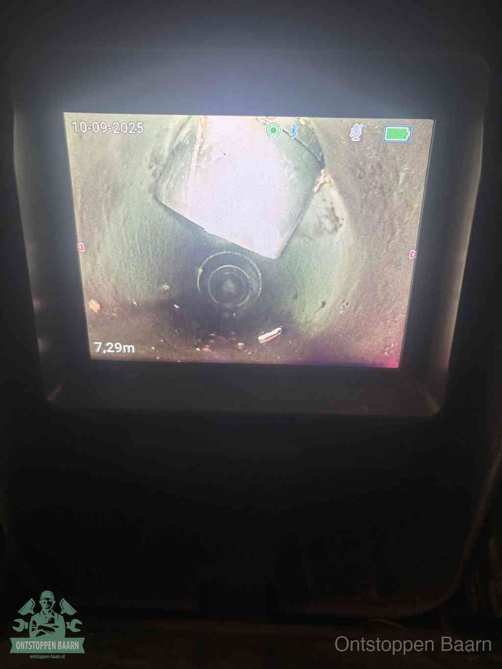 Het scherm van een rioolinspectiecamera toont de binnenkant van de leiding, eerst vaststellen waar de verstopping zit in Baarn