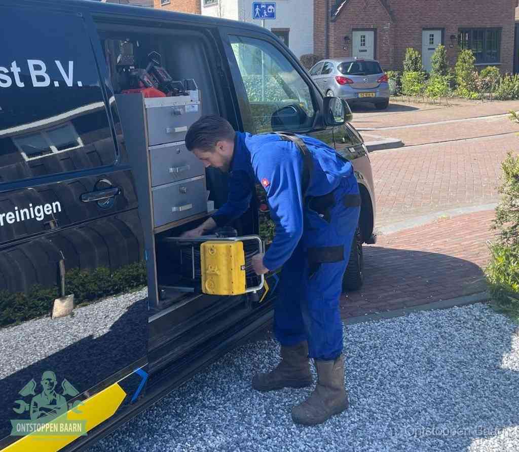 Een monteur pakt gereedschap uit de bedrijfsbus, het moment om een professionele ontstoppingsdienst in te schakelen in Baarn